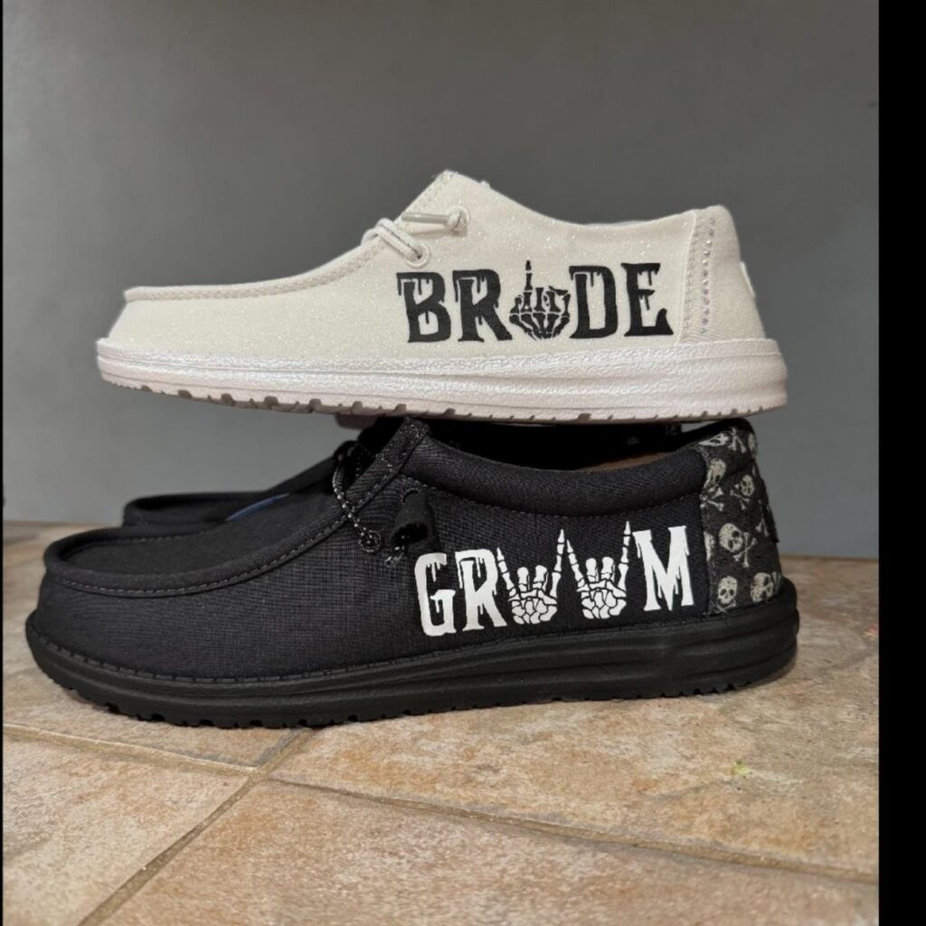 Cream and black slip-on shoes with bride and groom text printed on the sides.