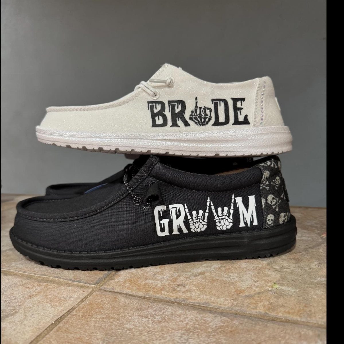 Cream and black slip-on shoes with bride and groom text printed on the sides.